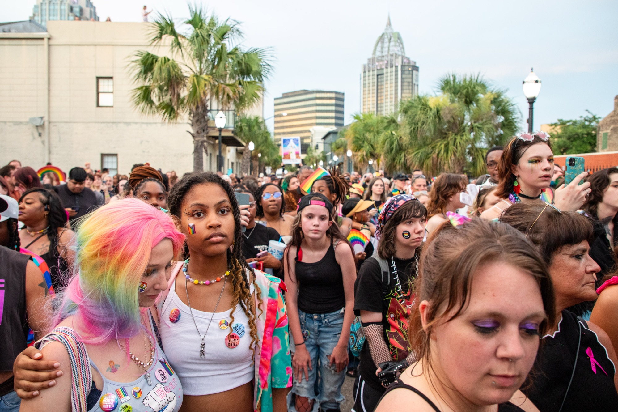 Pride art walk crowd beneath palms and the RSA tower